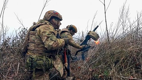 In this image made from video provided by Russian Defense Ministry Press Service on Tuesday, March 31, 2026, Russian soldiers fire a grenade launcher towards Ukrainian positions on an undisclosed location in Ukraine. 