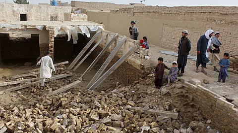 Locals inspect a damaged house following floods, landslides and thunderstorms in Kandahar province, Afghanistan, Sunday, March 29, 2026. 