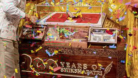 People offer prayers as confetti is showered during the display of the original manuscript of Shikshapatri at a temple, in London. The Shikshapatri, one of the world's most significant and rare Hindu scriptures, marks its 200th anniversary this year with a tour of Swaminarayan temples across the UK