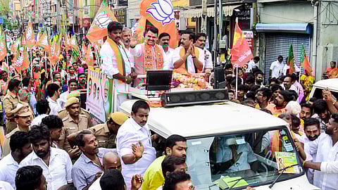 Maharashtra Chief Minister Devendra Fadnavis, centre, greets the gathering during an election campaign in support of BJP candidate for Madurai South constituency, Raama Srinivasan, right, ahead of the Tamil Nadu Assembly Election, in Madurai district
