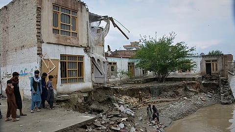 Residents inspect a building that partially collapsed due to heavy flooding in Jalalabad, Afghanistan