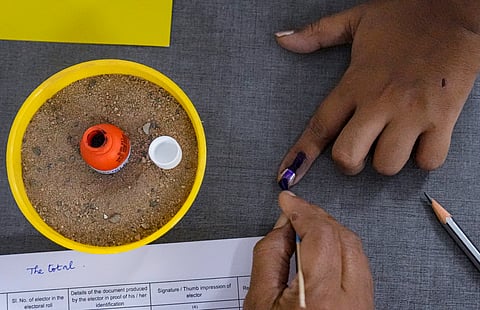 A voter gets her finger marked with indelible ink while casting vote during the Puducherry Assembly elections, at a polling station in Puducherry, Thursday, April 9, 2026