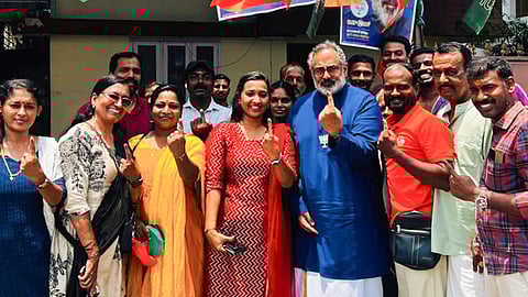 Kerala BJP President Rajeev Chandrasekhar, centre, shows his ink-marked finger with party workers after casting vote during the state Assembly elections, in Thiruvananthapuram 