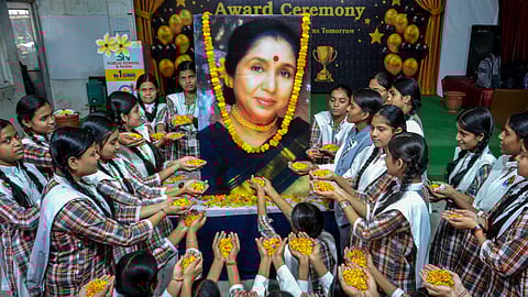 Students pay tributes to the late legendary playback singer Asha Bhosle, in Mirzapur, Monday, April 13, 2026 