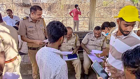 Police personnel collect details from locals following a road accident near Rayate Bridge on the Kalyan-Murbad Road, in Thane district, Maharashtra, Monday, April 13, 2026