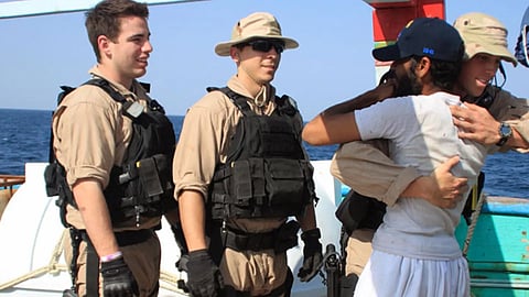 U.S. Navy sailors assigned to the guided-missile destroyer USS Kidd greet a crew member of the Iranian fishing vessel, the Al Molai Fin the Arabian Sea. 