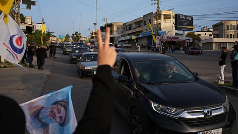 Displaced residents drive back to their villages as locals wave Hezbollah flags and an image of late Hezbollah leader Hassan Nasrallah, in Zefta, southern Lebanon, following a ceasefire between Israel and Hezbollah