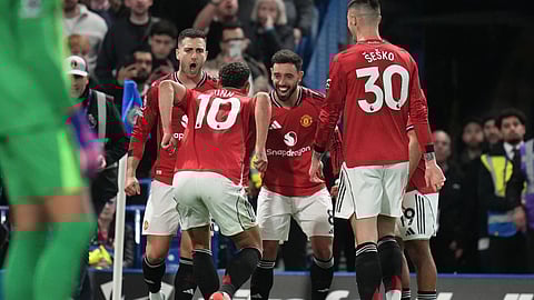 Manchester United's Matheus Cunha celebrates with teammates after scoring the opening goal during the English Premier League soccer match between Chelsea and Manchester United in London