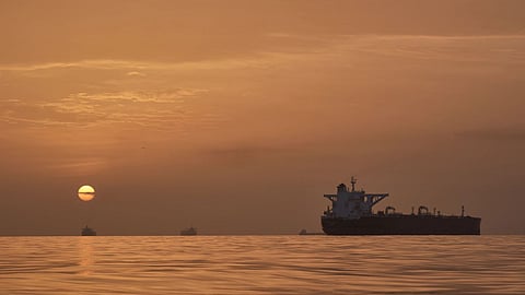 The sun rises behind tankers anchored in the Strait of Hormuz off the coast of Qeshm Island, Iran