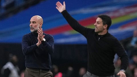 Manchester City's head coach Pep Guardiola, left encourages his players as Arsenal's manager Mikel Arteta gestures to his during the English League Cup final soccer match between Arsenal and Manchester City in London
