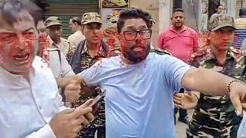 Security personnel detains a man after a clash erupted due to a glitch in EVM causing the voting to be delayed during the second and final phase of the West Bengal Assembly elections