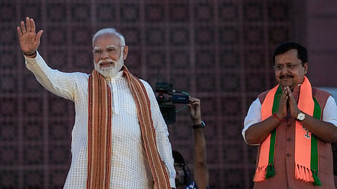 Prime Minister Narendra Modi waves to the gathering during an event celebrating the party's performance in Assembly elections across four states and one union territory, at the party headquarters in New Delhi