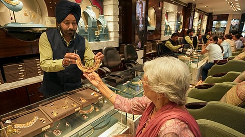 A customer checks a necklace at a jewellery shop, in Amrisar, Punjab, Wednesday, May 13, 2026