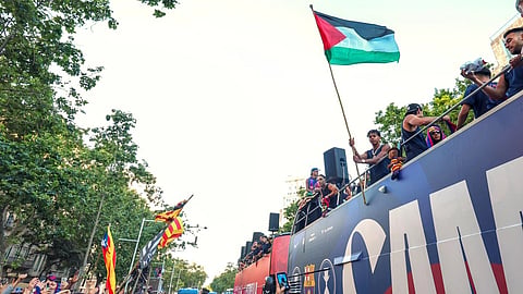 Lamine Yamal holds a Palestinian flag after winning the Spanish La Liga title in Barcelona.