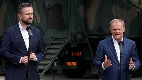 Poland's Prime Minister Donald Tusk, right, and Defense Minister Wladyslaw Kosiniak-Kamysz, visit troops who patrol Poland's border with Belarus, in Dubicze Cerkiewna, eastern Poland