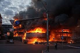 A man carries a box from a burning trade center after a Russian strike on Kyiv, Ukraine, on May 24, 2026. 