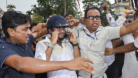 TMC General Secretary Abhishek Banerjee wears a helmet after stones, shoes and eggs were hurled at him during his visit to meet families of post-poll violence victims, in Sonarpur, West Bengal, Saturday, May 30, 2026 