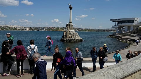 Tourists walk along an embankment in Sevastopol, Crimea