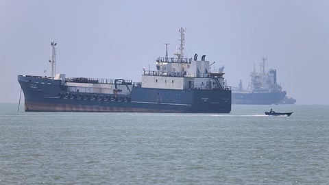 A small motorboat passes anchored vessels in the Strait of Hormuz 