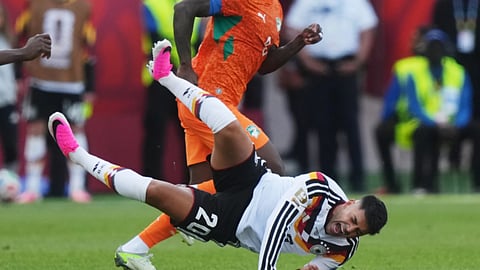 Germany's Nadiem Amiri (20) falls as Ivory Coast's Franck Kessie (back) looks on during the World Cup Group E soccer match 