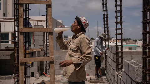 Jorge Moreno, a worker, drinks flavored water to cope with the heat wave during his workday at a construction site in Veracruz, Mexico, on June 17, 2024