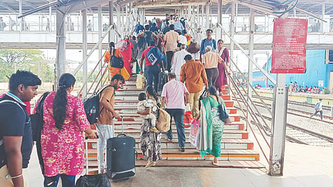 Passengers with kids and luggage struggling to climb the stairs to reach the foot over bridge on Platform 5