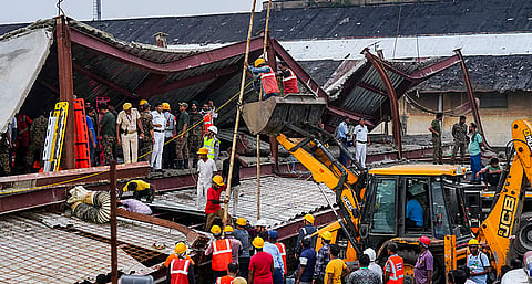 Officials and others gather during a rescue operation after a three-storey under-construction warehouse collapsed at Taratala area, in Kolkata, West Bengal