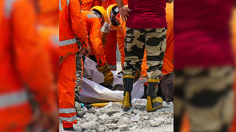 NDRF and Army officials carry the mortal remains of a victim during a rescue operation after an under-construction warehouse collapsed on Wednesday, leaving ten people dead and several others injured, in Kolkata's Taratala area, Thursday, June 25, 2026