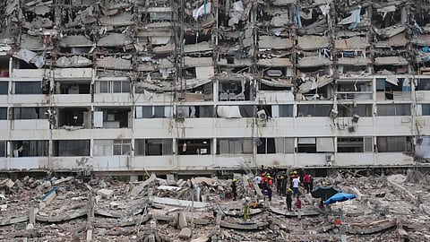Rescue workers search through the rubble of a building that collapsed when earthquakes struck La Guaira