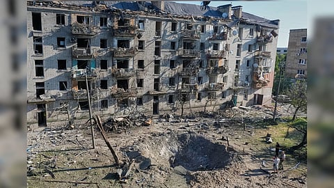 People look at the site of a Russian missile strike that hit a residential building in Kyiv, Ukraine.
