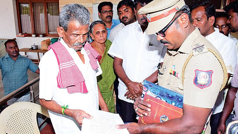 SIT personnel hand over summons to former minister Senthilbalaji’s father, Velusamy, at his residence in Karur on Saturday