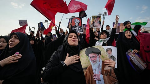 A mourner reacts while holding a portrait of the slain Iranian Supreme Leader Ayatollah Ali Khamenei as mourners gather in Islamic Revolution Square for Khamenei's funeral procession in Tehran