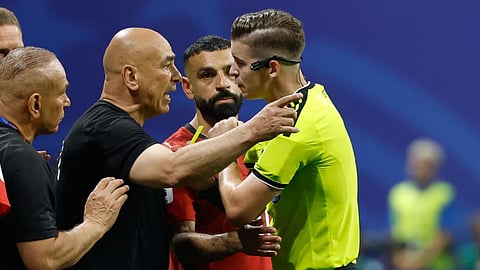 Egypt head coach Hossam Hassan argues with referee Francois Letexier, of France, during the World Cup round of 16 soccer match between Argentina and Egypt in Atlanta.