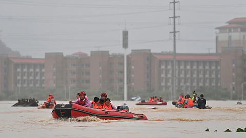 In this photo released by Xinhua News Agency, rescuers evacuate stranded teachers and students at Xijiang education park in the aftermath of tropical storm Maysak in Guigang City, south China’s Guangxi Zhuang Autonomous Region.