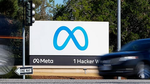 A car passes Facebook’s new Meta logo on a sign at the company headquarters in Menlo Park, Calif.