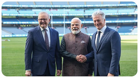 Prime Minister Narendra Modi, left, signs his autograph onto a cricket bat as former Australian cricketer Lisa Sthalekar looks on, at the Melbourne Cricket Ground, in Melbourne, Australia