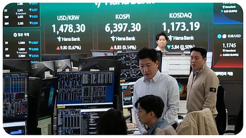 Currency traders work near a screen showing the Korea Composite Stock Price Index (KOSPI), top center, and the foreign exchange rate between U.S. dollar and South Korean won, top center left, at the foreign exchange dealing room of the Hana Bank headquarters in Seoul, South Korea, Wednesday, April 22, 2026.