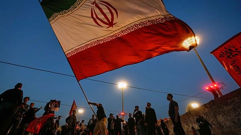 A man waves an Iranian flag during funeral ceremonies for slain Iranian Supreme Leader Ayatollah Ali Khamenei and members of his family at Imam Khomeini Mosalla Grand Mosque in Tehran, Iran.