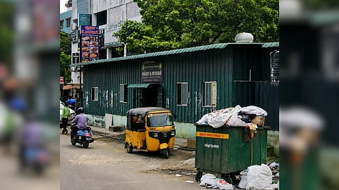An overflowing garbage bin sitting just a few feet from the entrance of Amma Unavagam near Tirumangalam Metro parking