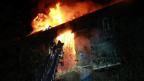 Rescue workers try to put out a fire of a residential building burning after a Russian drone attack on Zaporizhzhia, Ukraine, late Sunday, July 12, 2026. (AP Photo/Kateryna Klochko)