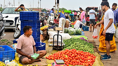 People buy vegetables at a wholesale market, in Prayagraj