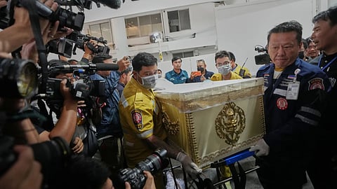 A coffin of a victim in a music bar fire is prepared to be handed over to the relatives, unseen, at a police hospital in Bangkok, Thailand.