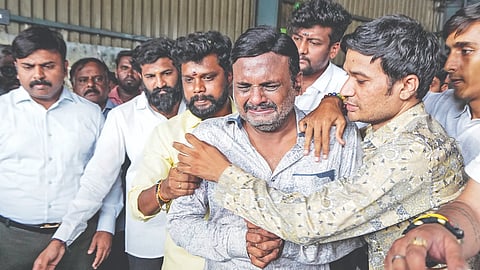 A man breaks down as the mortal remains of his loved one