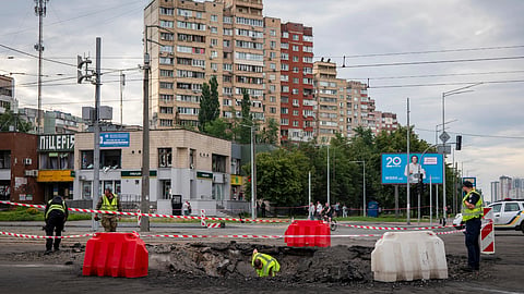 A sapper examines the impact site of a Russian missile in a residential area of Kyiv, Saturday, July 11, 2026