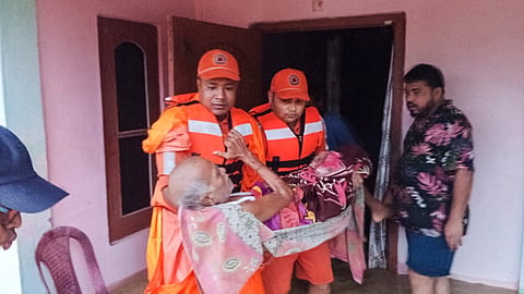  NDRF officials conduct a rescue operation in a flood-affected area, in Assam