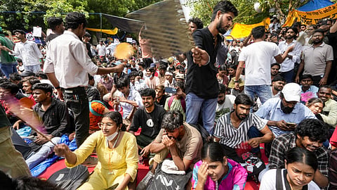 Volunteers fan protesters amid the ongoing demonstration over the alleged NEET-UG examination irregularities at Jantar Mantar, in New Delhi.