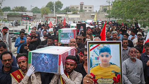Mourners carry the coffins containing additional remains of victims identified through DNA testing during funeral ceremonies in Minab, Iran