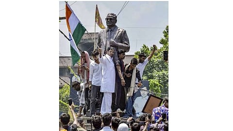  RJD leader Tej Pratap Yadav stands atop the statue of former Mauritius Prime Minister Seewoosagur Ramgoolam during the 'Bihar Bandh' called over the alleged NEET paper leak and police action against protesting students, at Ram Gulam Chowk, in Patna, Bihar, Saturday, July 25, 2026
