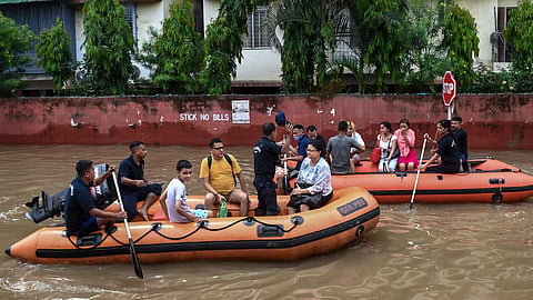 SDRF personnel rescue people from a water logged area following rainfall, at Rukmini Gaon, in Guwahati, Friday, July 24, 2026