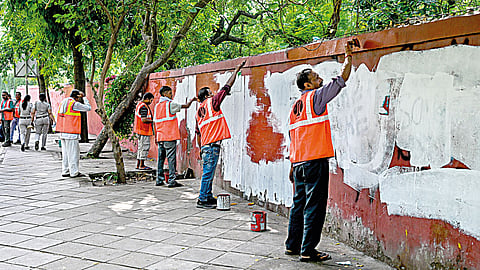 Workers paint over graffiti at Jantar Mantar on July 26 after the Cockroach Janta Party called off its agitation.